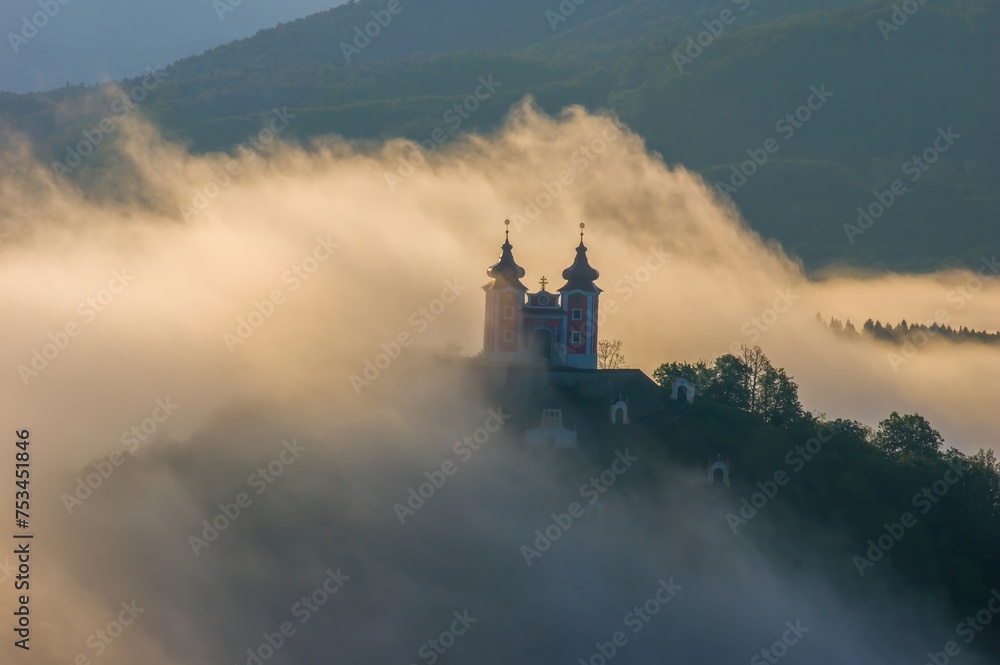 Amazing natural scenery with fog and a historical building obscured in the fog. Beautiful natural view, wet weather