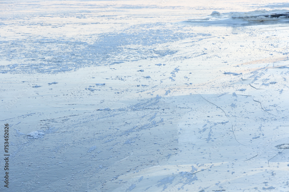 A beautiful cracked ice patterns on the frozen lake surface during winter in Latva. Cold scenery of Northern Europe. A beautiful cracked ice patterns on the frozen lake surface during winter in Latva. Cold scenery of Northern Europe.