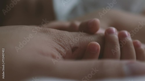 A toddler holding father hand during baby sleeping. Father taking care of her son kid happy family dream of health