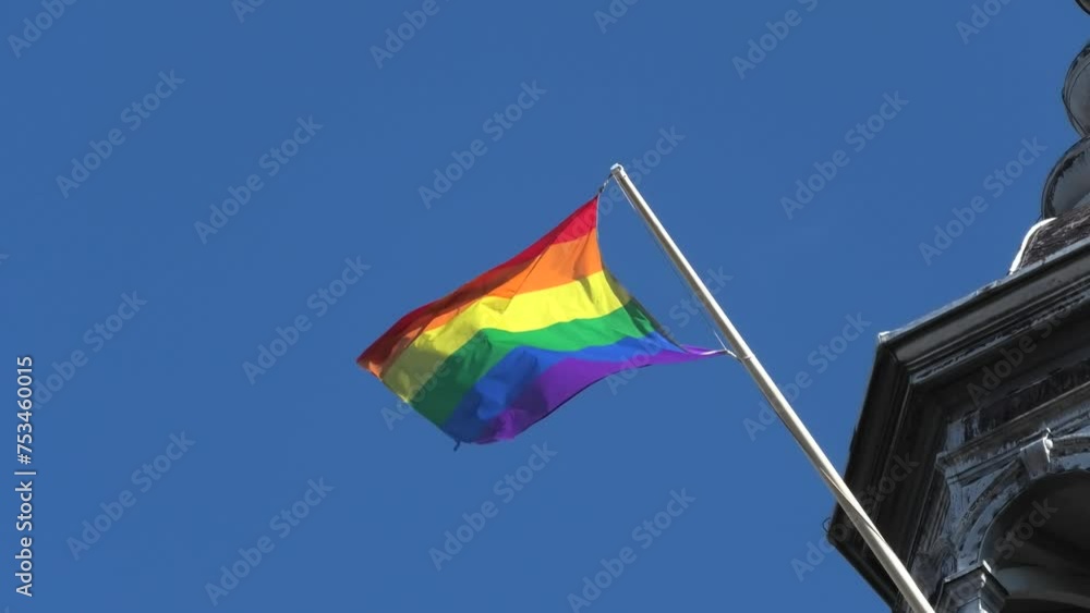 Rainbow flag, symbol of gay pride waving on top of a building Rainbow flag, symbol of gay pride waving on top of a building