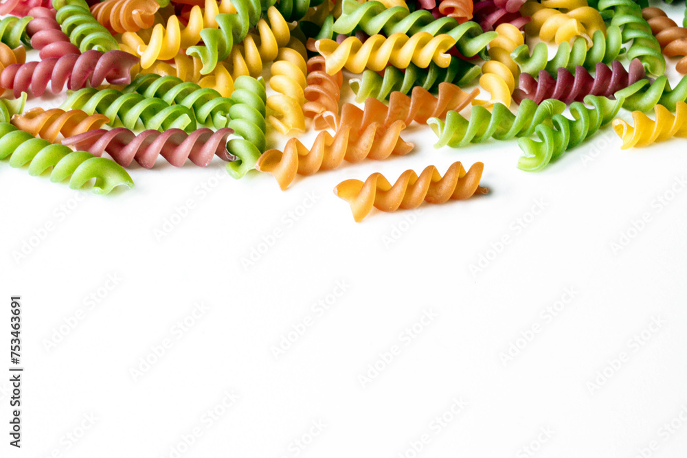 Background of colored spiral noodles with space for text. Abstract texture of colorful pasta. Bright multicolor food backdrop. Food for children. The concept of proper nutrition
