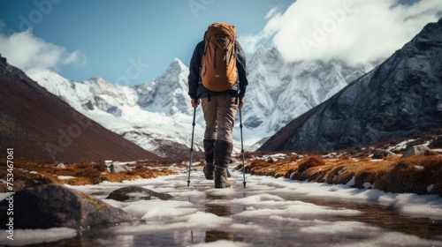 Male athlete in hiking, trekking shoes traveling among mountainous landscape with equipment on a winter sunny day.