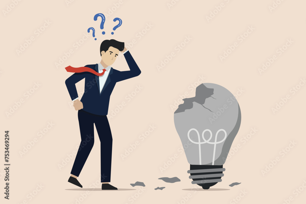 Failed idea, looking for a solution to the cause of business failure, confused businessman looking at a broken idea light bulb. Failed idea, looking for a solution to the cause of business failure, confused businessman looking at a broken idea light bulb.