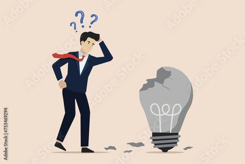 Failed idea, looking for a solution to the cause of business failure, confused businessman looking at a broken idea light bulb.