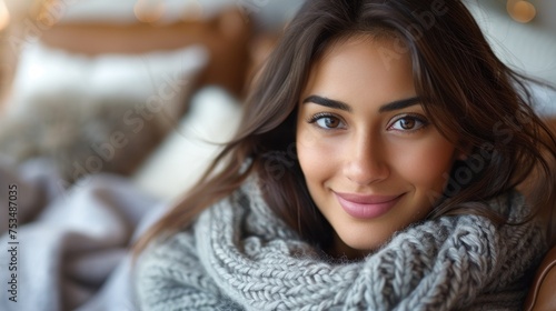 A woman with a smile wearing a gray scarf