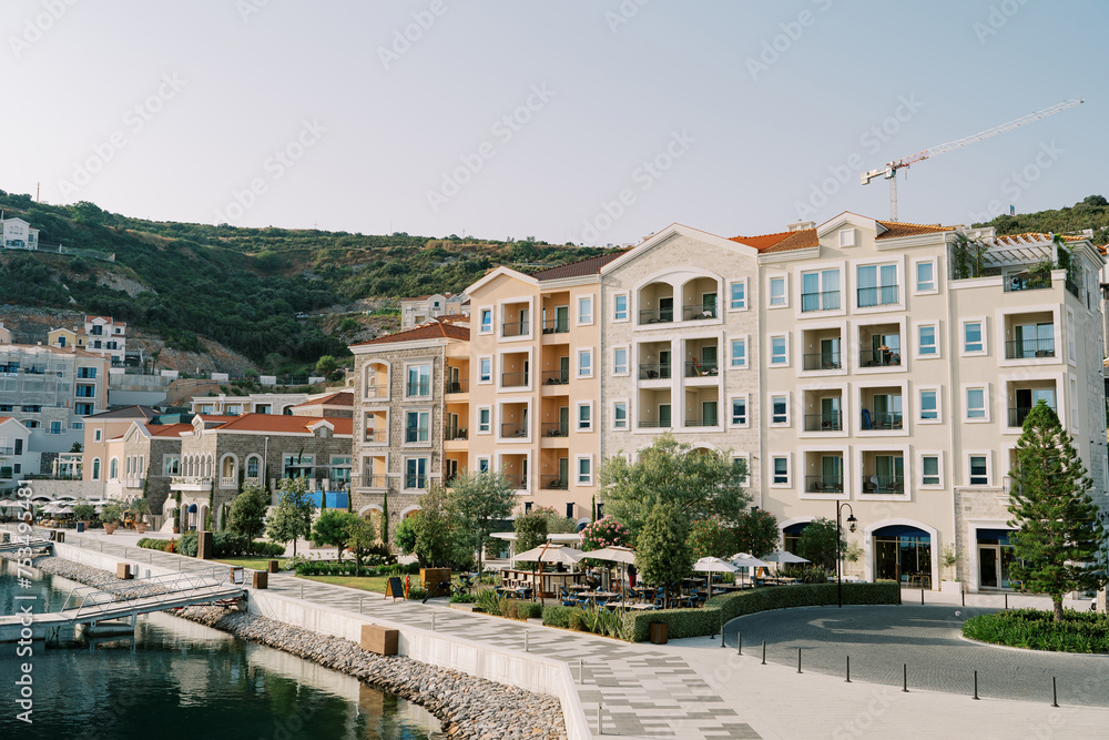 Colorful apartment buildings on the sea promenade at the foot of the mountains