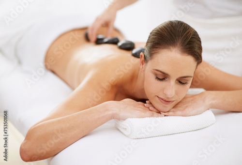 Relax, hot stone massage and girl at spa for health, wellness and luxury holistic treatment. Self care, zen and woman in natural body therapy, comfort and calm pamper service at hotel with therapist