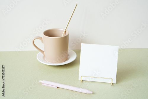 Blank memopad with holder, pen, mug cup on desk. white ivory background. workspace office stationery photo