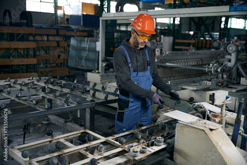 Middle-aged male processes the edge of glass using high-tech equipment