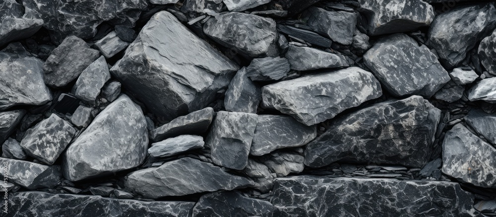 A close-up black and white shot of a heap of rocks, showing the intricate details and textures of granite stones piled on top of each other. A close-up black and white shot of a heap of rocks, showing the intricate details and textures of granite stones piled on top of each other.
