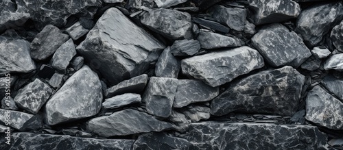 A close-up black and white shot of a heap of rocks, showing the intricate details and textures of granite stones piled on top of each other.