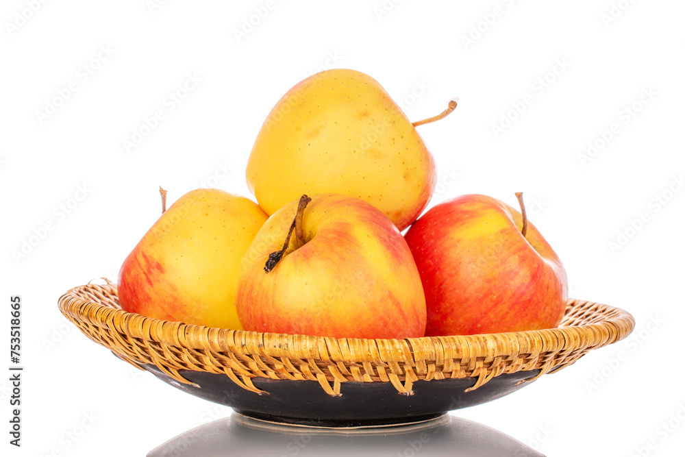 Several yellow apples on a ceramic plate, macro, isolated on a white background.