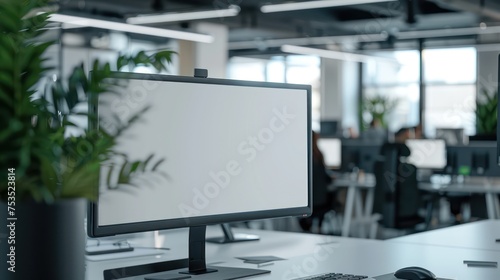 A mockup displaying a blank white screen monitor with a modern office workspace background.
