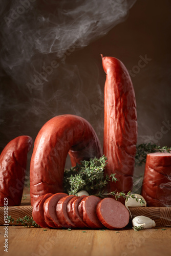 Smoked sausage with thyme and garlic on a wooden table.