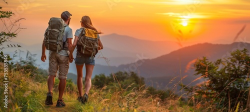 Adventurous hikers exploring mountain trail at sunset, backpacking journey in nature