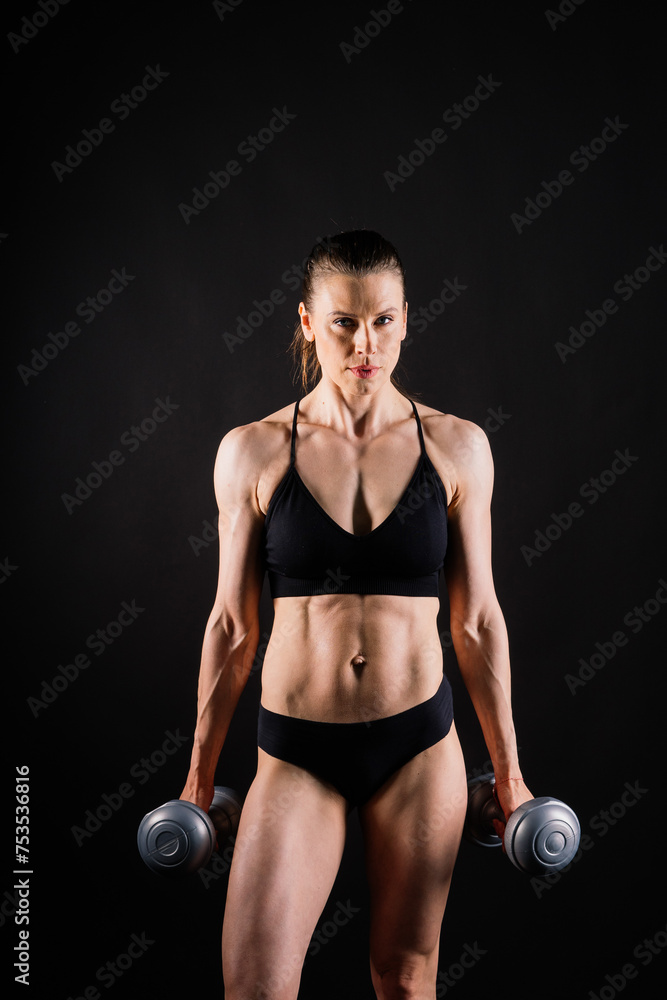 Sporty female doing exercise with dumbbells, silhouette studio shot dark yellow background Sporty female doing exercise with dumbbells, silhouette studio shot dark yellow background