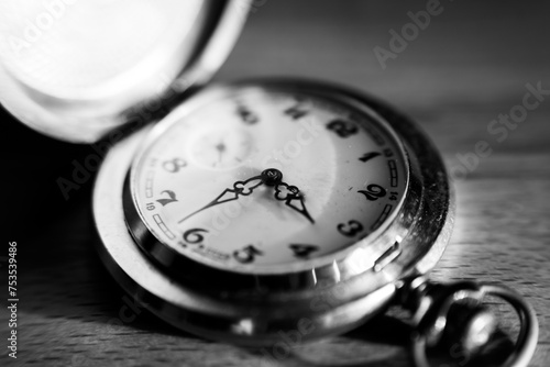 Black and white macro old metal watch lies on the surface