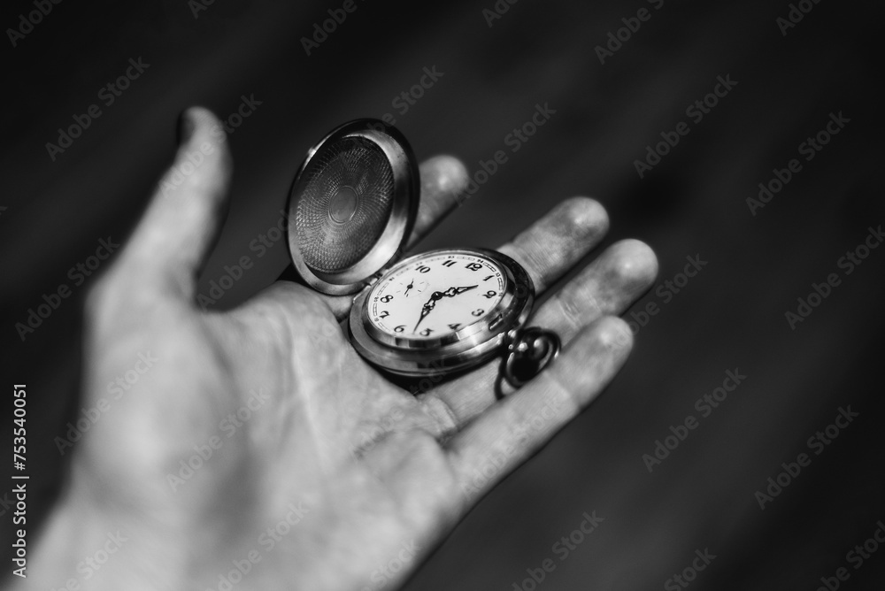 Black and white Hand holding an old metal watch Black and white Hand holding an old metal watch