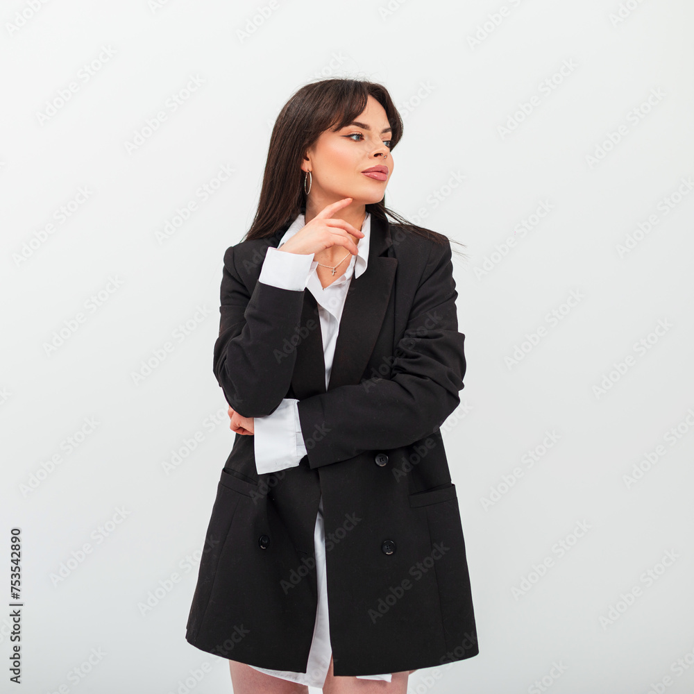 Beautiful fashion young woman with hairstyle in a stylish black blazer with a white shirt posing on a white background in the studio Beautiful fashion young woman with hairstyle in a stylish black blazer with a white shirt posing on a white background in the studio