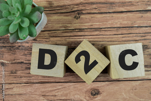 Concept of The wooden Cubes with the word D2C - Direct to Consumer on wooden background.