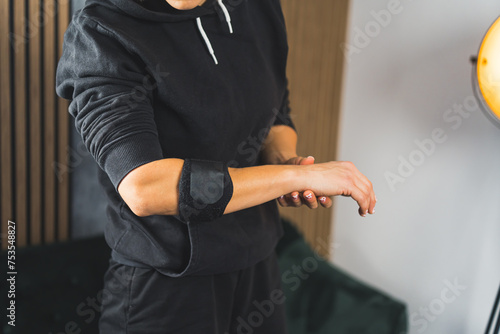 woman wearing an elbow support brace at home  rehabilitation process. High quality photo