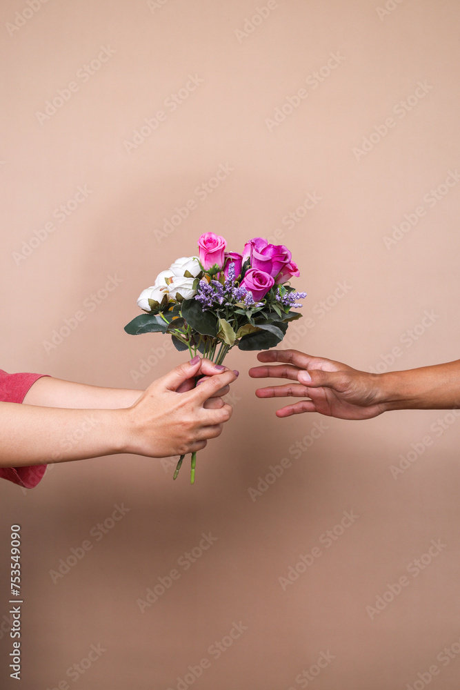 Male hand giving bouquet of flowers and female hand taking it. Concept of Mother's Day, Valentine Day and Women's Day