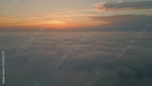 Amazing sunrise fluffy clouds aerial view. Golden horizon at summer morning