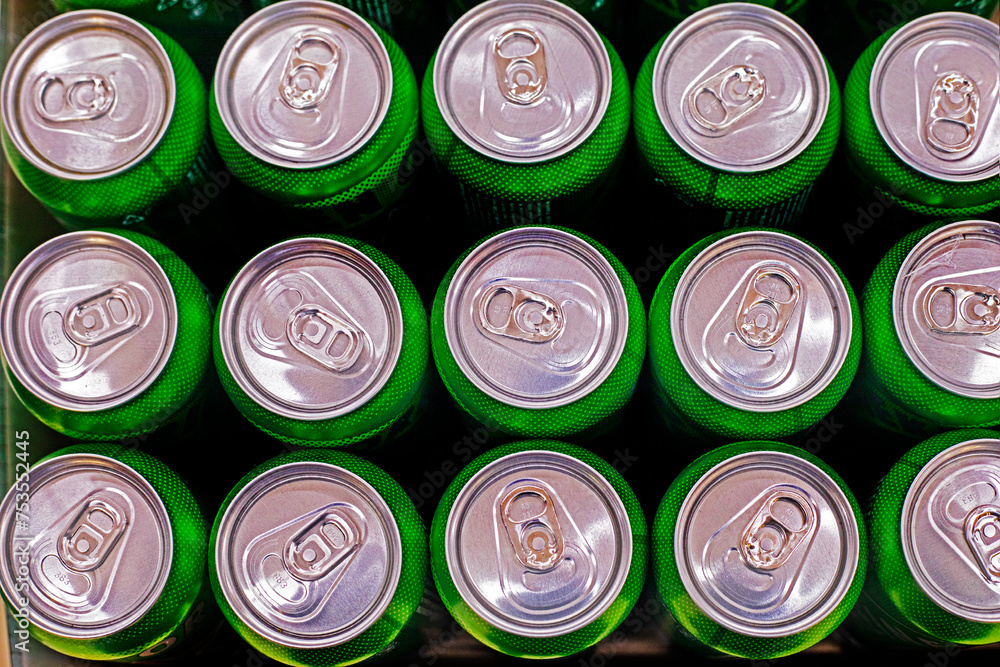 Energy drinks in aluminum green containers in a supermarket, top view Energy drinks in aluminum green containers in a supermarket, top view