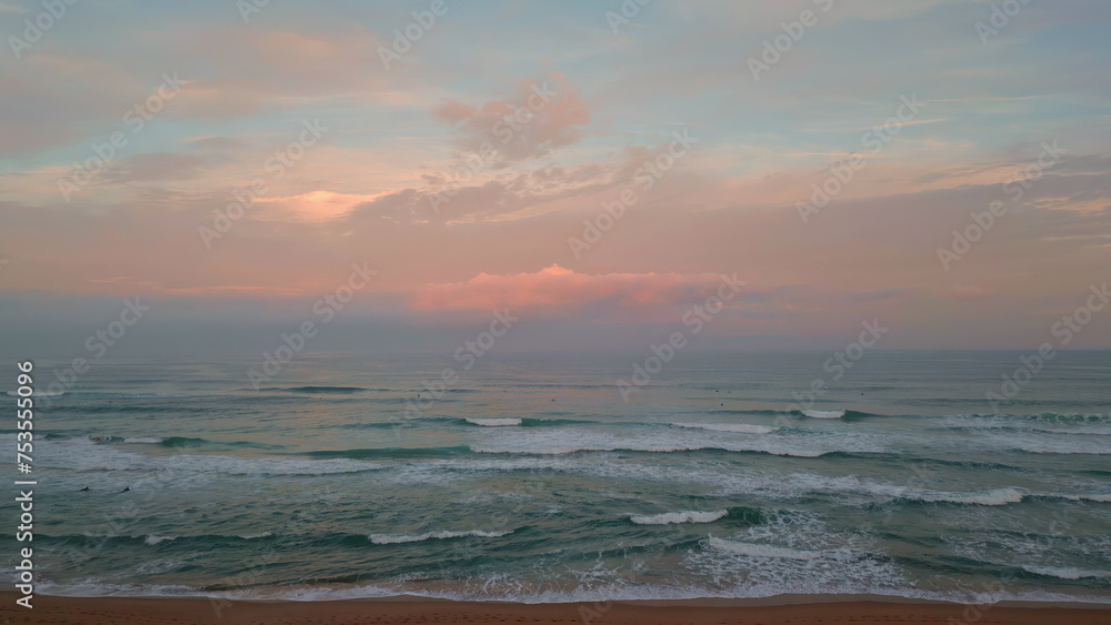 Amazing ocean sunset aerial view. Cinematic sea water washing sandy beach 