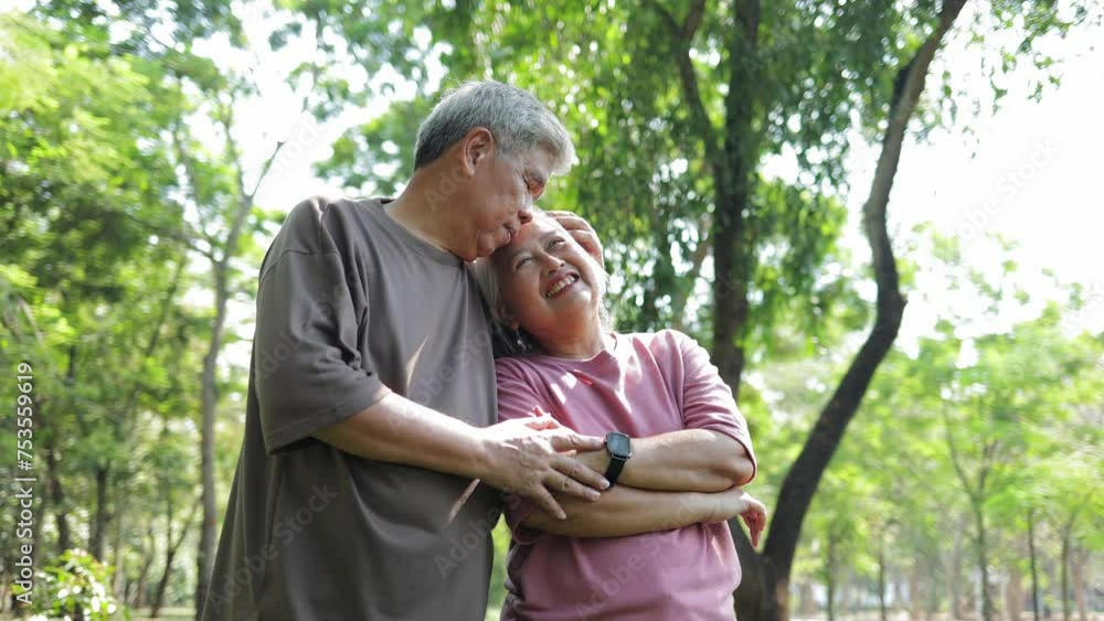Elderly Asian couple standing and hugging each other in the garden. They smile happily. Living happily in retirement. Health care. Elderly society