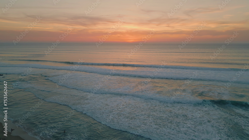 Peaceful ocean evening dusk with golden cloudy sky over endless horizon aerial 