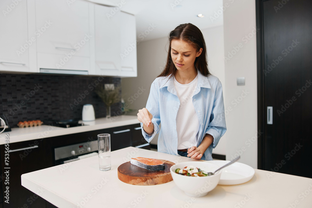 Beautiful young woman cooking healthy food in modern kitchen at home, promoting healthy diet and lifestyle concept Beautiful young woman cooking healthy food in modern kitchen at home, promoting healthy diet and lifestyle concept