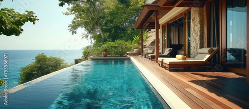 Covered outdoor pool with teak deck and exotic flooring stripes around the blue water.