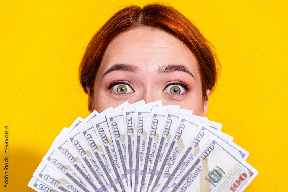 Photo of excited funky woman holding currency fan cover mouth isolated yellow color background Photo of excited funky woman holding currency fan cover mouth isolated yellow color background