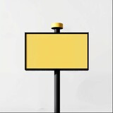 An eye-catching vertical billboard stands with a vibrant yellow backdrop framed in black, mounted on a sleek black pole with a flat base for stability. The blank yellow canvas suggests potential for a