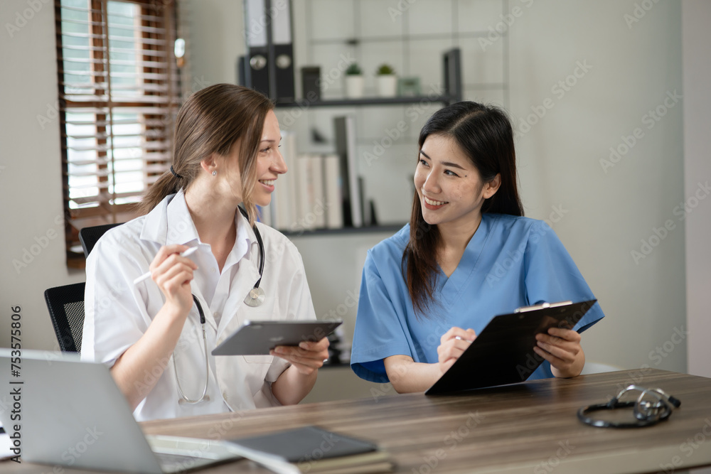 Female doctor sitting at work looking at the history of patients in the clinic or in the hospital