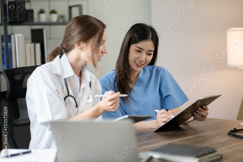 Female doctor sitting at work looking at the history of patients in the clinic or in the hospital