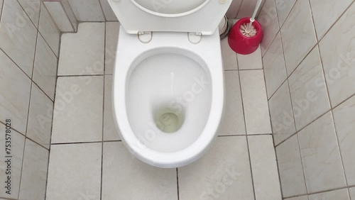 Toilet with urine residue in a tiled bathroom photo