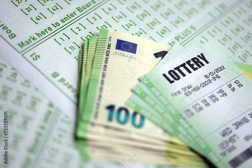 Green lottery tickets and euro money bills on blank with numbers for playing lottery close up