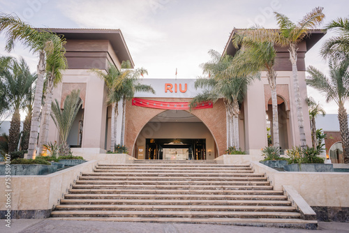 Agadir, Morocco - February 25, 2024 - Entrance of the RIU hotel with palm trees, stairs, and a red carpet welcoming guests. photo