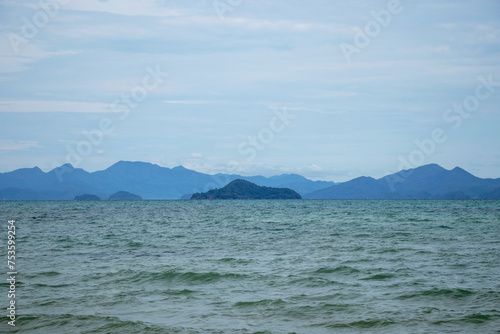 The ocean is calm and the sky is cloudy. The mountains in the background are visible © Andryukha