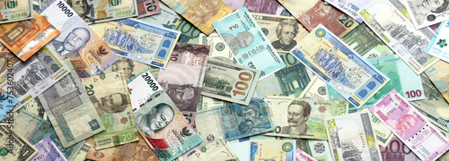 Many banknotes of different currency. Background of big amount of random money bills close up