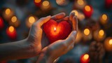 This image shows a glowing red heart in hands, symbolizing love, romance, , wedding, anniversary, charity, and donation,human palms holding red shining heart in the dark,concept of global love day 

