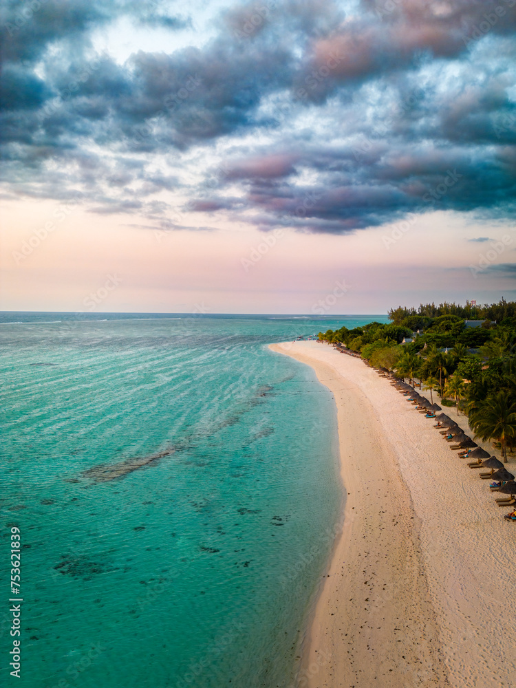 Tropical Elegance from Above: Aerial Sunset View of Serene Beach and Lush Greenery