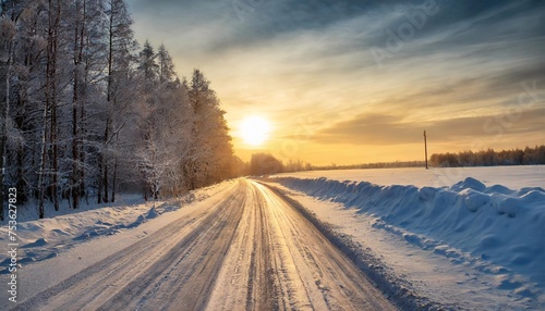 beautiful view of the sunset in the evening on the country snowy road