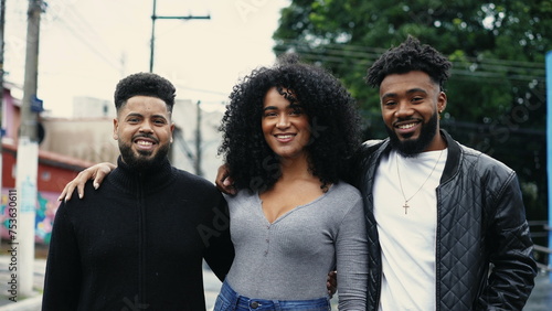 Group of Brazilian friends smiling at camera standing in city street. Latin South American people of African American descent portrait faces