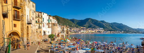 Panoramic view of tourists on beach, mountains in background, Cefalu, Province of Palermo, Sicily, Italy