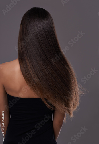 Hair care, wind and back of woman with beauty, shine or body isolated on a gray studio background. Hairstyle, cosmetics and rear view of model in salon for treatment, growth or hairdresser for glow