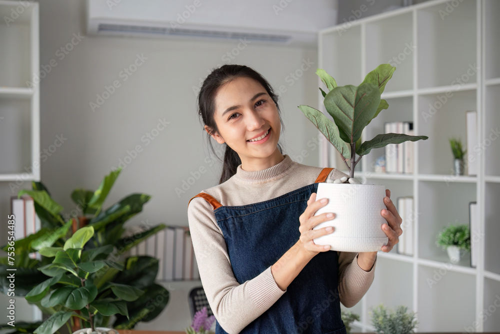 A young Asian woman is enjoying planting a garden in her home to create a shady atmosphere in her home. A young Asian woman is enjoying planting a garden in her home to create a shady atmosphere in her home.