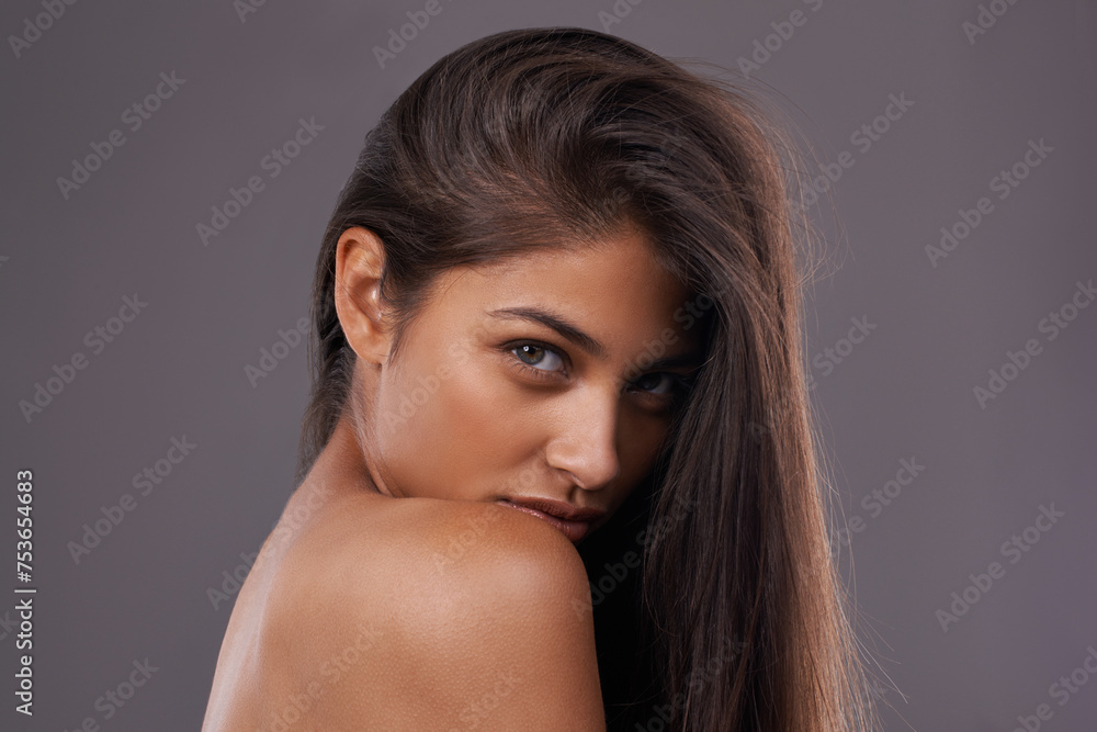 Naklejka premium Woman, studio and haircare with natural beauty, Indian female person with luxury and salon treatment. Nourishing and keratin blowout for results and wellness, confident and isolated glowing model